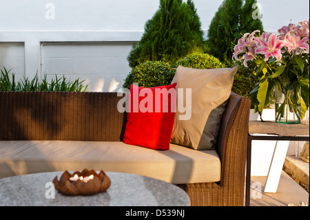 Patio extérieur, coin salon avec canapé en rotin de nice au coucher du soleil Banque D'Images