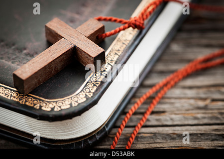 Gros plan du collier croix chrétienne en bois simple sur la sainte Bible Banque D'Images