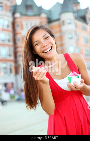 Asie multiculturelle joyeuse Caucasian woman smiling robe d'été en rouge et la consommation de crème glacée devant le Château Frontenac Banque D'Images