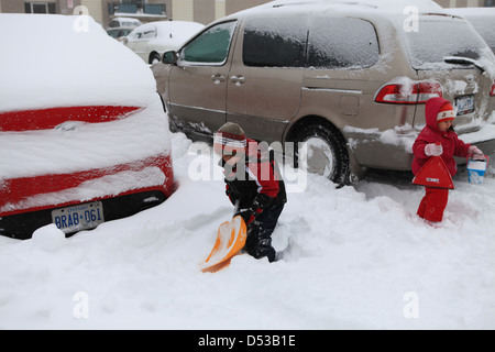 Les enfants jouent dans la neige en Ontario, Canada Banque D'Images