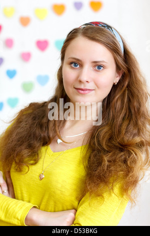 Portrait d'une jeune et belle cheerful brunette smiling girl avec de longs cheveux rouges dans le chemisier jaune Banque D'Images