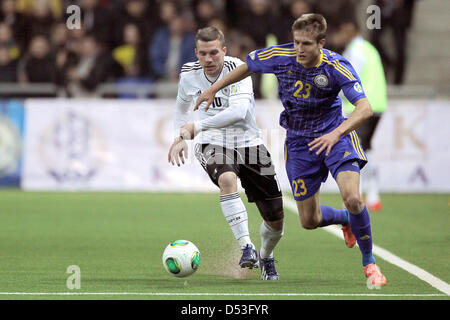 Astana, Kazakhstan. 22 mars 2013. L'Allemagne s'acharne pour Lukas Podolski le ballon avec le Kazakhstan's Baurzhan Jolchiyev pendant la Coupe du Monde FIFA 2014 football match de qualification du groupe C entre le Kazakhstan et l'Allemagne à Astana Arena à Astana, Kazakhstan, le 22 mars 2013. Photo : Fredrik von Erichsen/dpa/Alamy Live News Banque D'Images