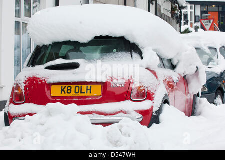 Llangollen, Wales, UK. Le 24 mars 2013. La neige est 80cms de profondeur dans des endroits à Llangollen et beaucoup de visiteurs pris au piège le vendredi soir, lorsque le poids de la neige ont rendu les routes impraticables, maintenant faire une tentative de creuser leurs voitures et rentrer chez eux. Les sections locales également essayer d'obtenir leurs véhicules libres pour travailler demain. La neige continue de tomber, mais moins fortement et les températures restent sous zéro. Crédit photo : Graham M. Lawrence/Alamy Live News. Banque D'Images