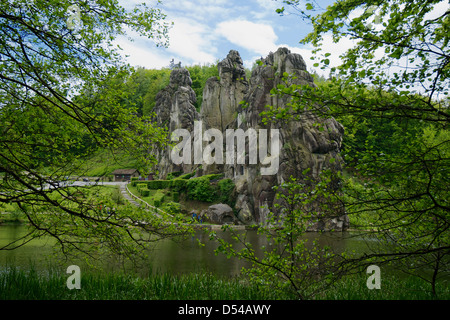 Aperçu de l'ensemble des Externsteine rock formation de branches d'arbre au premier plan. Banque D'Images