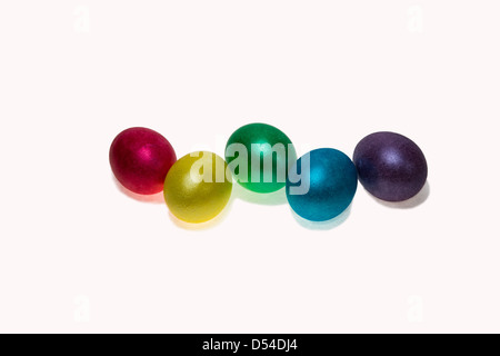 Rangée de cinq oeufs de Pâques de rouge, jaune, vert, bleu, violet color isolé sur fond blanc Banque D'Images