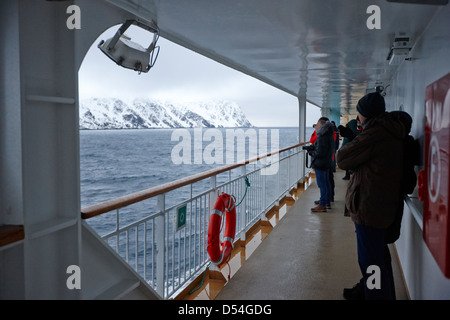 Passagers à bord du navire à passagers hurtigruten voile à travers les fjords en hiver la norvège europe Banque D'Images