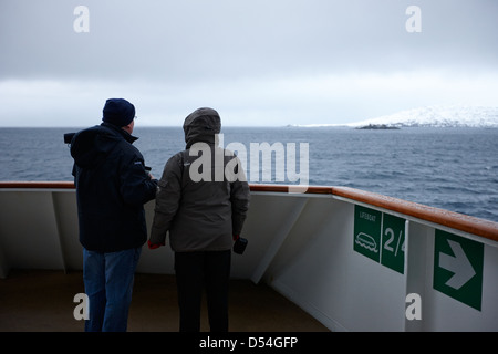 Passagers à bord du navire à passagers hurtigruten voile à travers les fjords en hiver la norvège europe Banque D'Images