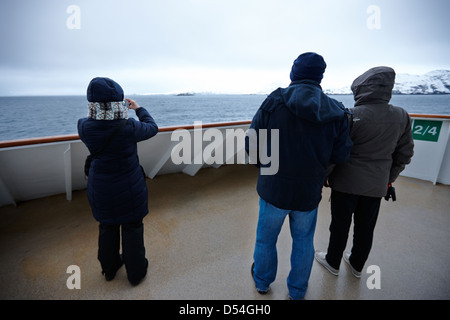 Passagers à bord du navire à passagers hurtigruten voile à travers les fjords en hiver la norvège europe Banque D'Images