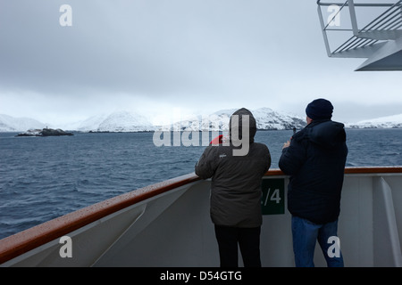 Passagers à bord du navire à passagers hurtigruten voile à travers les fjords en hiver la norvège europe Banque D'Images