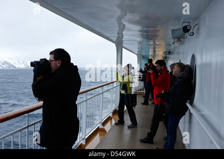 Passagers à bord du navire à passagers hurtigruten voile à travers les fjords en hiver la norvège europe Banque D'Images