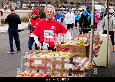 Coureur de marathon d'atteindre pour les fruits après course Banque D'Images