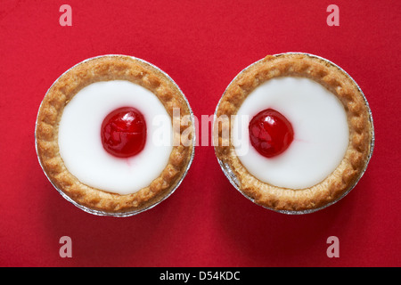 2 Mr Kipling cherry tartelettes Bakewell isolé sur fond rouge Banque D'Images