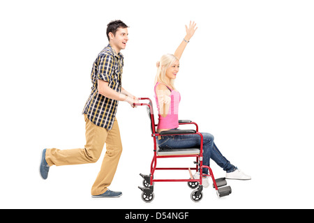 Portrait d'un homme heureux de pousser un fauteuil roulant en femelle isolé sur fond blanc Banque D'Images
