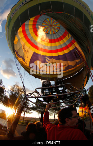 Un membre d'équipage chauffe l'air à l'intérieur d'un ballon à air chaud enveloppe avant un vol. Banque D'Images