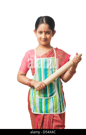 Portrait d'une fille imitant comme femme tenant un rouleau à pâtisserie Banque D'Images