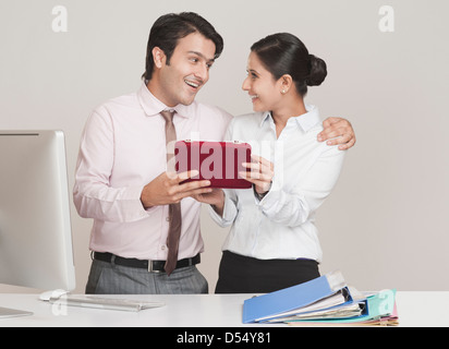 Businessman giving gift to a businesswoman in office Banque D'Images