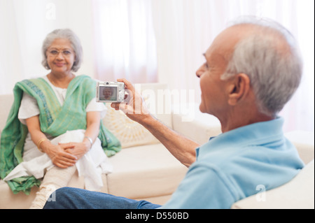 L'homme de prendre une photographie de sa femme avec un appareil photo Banque D'Images