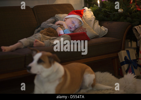 Boy in Santa hat sleeping on sofa Banque D'Images