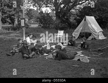 Camp scouts, ch. 1930 avec la tente et de scouts et de manger des sandwichs master Banque D'Images