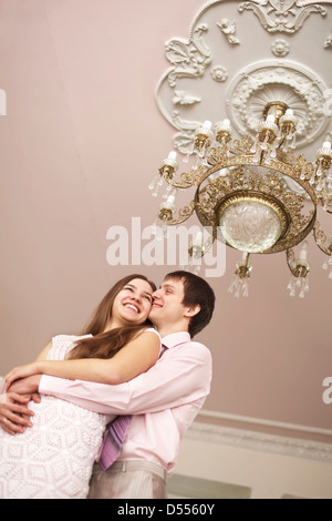 Couple hugging sous lustre orné Banque D'Images