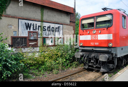 ILLUSTRATION - Une photo de fichier datée du 02 septembre 2011 montre un vieux panneau indiquant la gare de Wuensdorf et un train express régional de la Deutsche Bahn à Wuensdorf, en Allemagne. Fotoarchiv für Zeitgeschichte () Banque D'Images