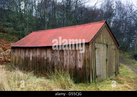 Cabane en bois avec toit en tôle ondulée au Loch Ruthven, une réserve près de RSPB Dores dans l'Inverness-shire, Scotland Banque D'Images