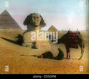 Le Grand Sphinx de Gizeh, situé en Egypte, est une sculpture monumentale datant de l'Egypte ancienne. Cette photographie teintée à la main capture le Sphinx sur fond de désert, avec les pyramides de Gizeh visibles au loin. Banque D'Images