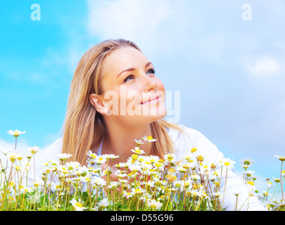 Beautiful woman enjoying daisy field and blue sky, belle femme couché dans la prairie de fleurs, jolie fille relaxant à l'extérieur Banque D'Images