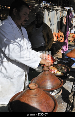 Le tagine étant cuit dans des pots traditionnels en faïence de tagine le jour du marché à Jemaa d'Rehmat . Au sud de Marrakech, Maroc Banque D'Images