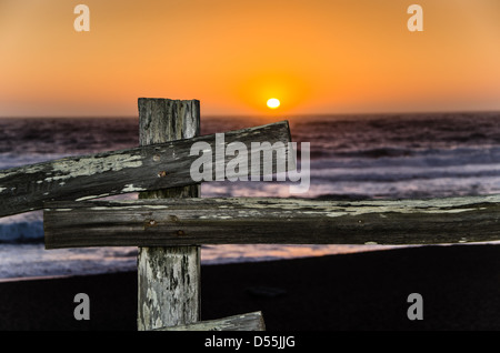 Coucher du soleil d'été sur une plage de Californie avec une clôture en bois au premier plan. Banque D'Images