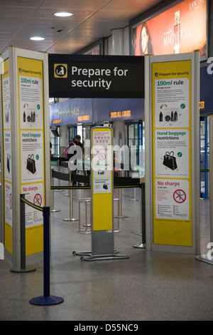 Vérification de sécurité sur les bagages à main gate avec panneaux d'avertissement et information sur les produits interdits et restreints. L'aéroport de Gatwick (Londres) sth. Banque D'Images