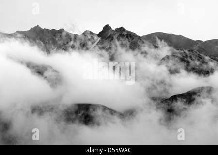 Vue en noir et blanc des nuages bas, la brume et le brouillard obscur partiellement la chaîne de l'Alaska, Denali National Park, Alaska, USA Banque D'Images