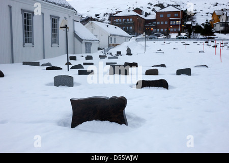 Pierres tombales partiellement enterré dans la neige dans le cimetière à l'extérieur de l'Église de Norvège finnmark Honningsvag kirke europe Banque D'Images