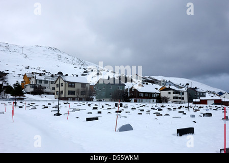 Pierres tombales partiellement enterré dans la neige dans le cimetière à l'extérieur de l'Église de Norvège finnmark Honningsvag kirke europe Banque D'Images