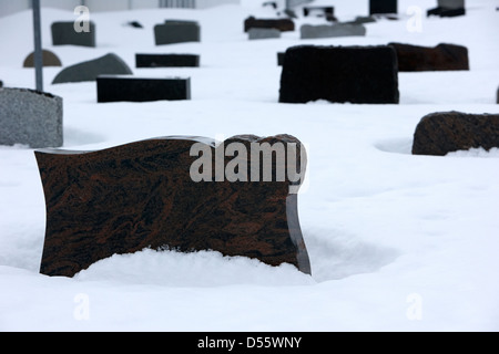Pierres tombales partiellement enterré dans la neige dans le cimetière à l'extérieur de l'Église de Norvège finnmark Honningsvag kirke europe Banque D'Images