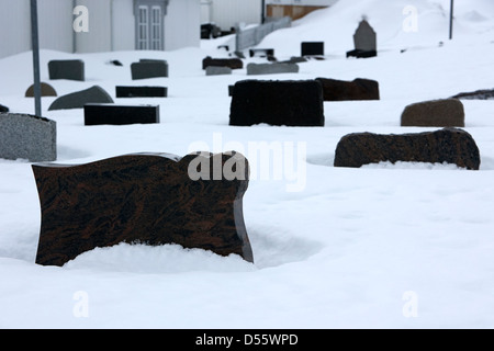 Pierres tombales partiellement enterré dans la neige dans le cimetière à l'extérieur de l'Église de Norvège finnmark Honningsvag kirke europe Banque D'Images