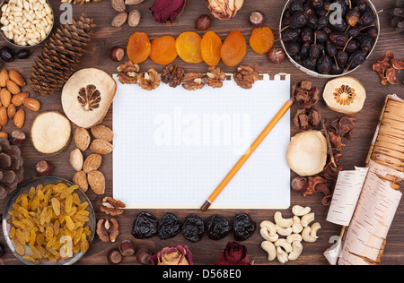 Feuille de papier blanc avec un crayon dans un environnement de noix et fruits Banque D'Images