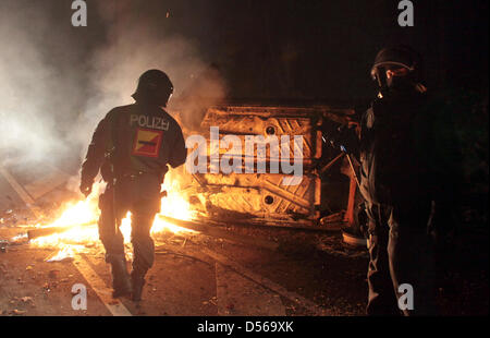 Les agents de police effacer un blocage routier entre Lunebourg et Dannenberg, Allemagne, 07 novembre 2010. Les adversaires de l'énergie supprimer totalement mis le feu à une voiture et des bottes de paille sur une autoroute. Le transport du nucléaire français installation de retraitement de La Hague à l'installation de stockage intérimaire à Gorleben. Photo : Kay Nietfeld Banque D'Images