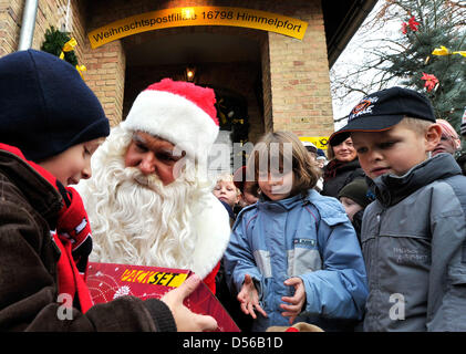 Le Père Noël distribue des cadeaux aux enfants lors de l'ouverture du bureau de poste de Noël Himmelpfort, Allemagne, 11 novembre 2010. L'année dernière, le Père Noël a reçu 280 000 voeux de Noël du monde entier. Photo : BERND SETTNIK Banque D'Images