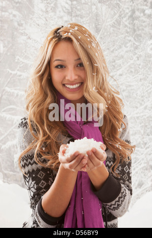 Mixed Race woman holding poignée de neige Banque D'Images