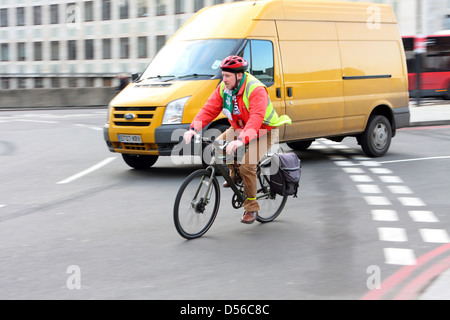 Un cycliste et van entrer dans un rond-point à Londres, en Angleterre. Banque D'Images