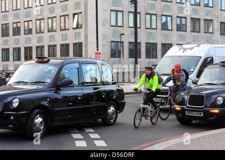 Les cyclistes et le trafic entrant dans un rond-point à Londres, en Angleterre. Banque D'Images