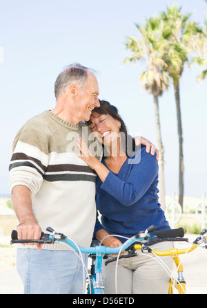 Couple walking on beach vélos Banque D'Images