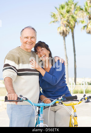 Couple walking on beach vélos Banque D'Images