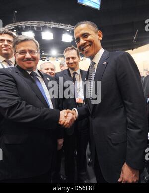 Le président américain Barack Obama et le président polonais Bronislaw Komorowski se serrent la main sur la première nuit de la conférence au sommet de l'OTAN à Lisbonne, Portugal, 19 novembre 2010. Environ 50 chefs d'Etats sont attendus pour les deux jours de réunion au sommet. Principaux thèmes qui seront abordés sont une coopération européenne pour l'assemblage d'une politique de défense antimissile en Europe ainsi que Banque D'Images