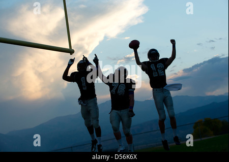 Les joueurs de football cheering in game Banque D'Images