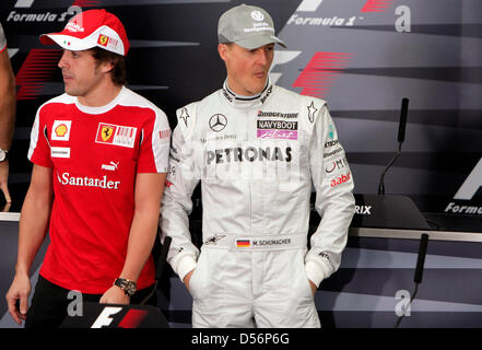 Pilote de Formule 1 espagnol Fernando Alonso de la Scuderia Ferrari (L) et l'Allemand Michael Schumacher de Mercedes GP (R) au cours d'une conférence de presse à Bahreïn International circuit de Sakhir, à Bahreïn, le 11 mars 2010. Photo : Jens Buettner Banque D'Images