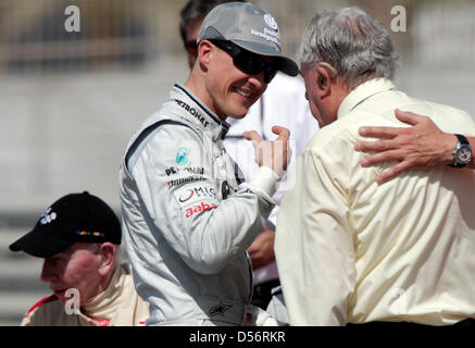 L'Allemand Michael Schumacher (L) de Mercedes Grand Prix de l'entretient avec l'ancien Champion du Monde de Formule 1 John Surtees en marge du Grand Prix de Bahreïn à la piste de course de Sakhir, à Bahreïn, le 14 mars 2010. Photo : Jens Buettner Banque D'Images