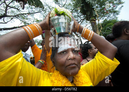 Singapour. 26 mars 2013. Une femme dévote au festival de Thaipusam porte un pot de lait sur sa tête. Le festival de Thaipusam commémore la victoire du bien sur le mal et est célébré par les dévots hindous qui portent le fardeau physique connu comme Kavadi avec porteurs et prendre leurs joues piercing et des langues. Credit : amer ghazzal / Alamy Live News Banque D'Images