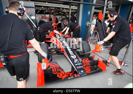 L'équipe de mécaniciens de course vierge pousser la voiture de l'Allemand Timo Glock de nouveau dans le garage pendant la première session d'essais du Grand Prix d'Australie à l'Albert Park à Melbourne, Australie, 26 mars 2010. Le Grand Prix d'Australie aura lieu le 28 mars 2010. Photo : Jens Buettner Banque D'Images